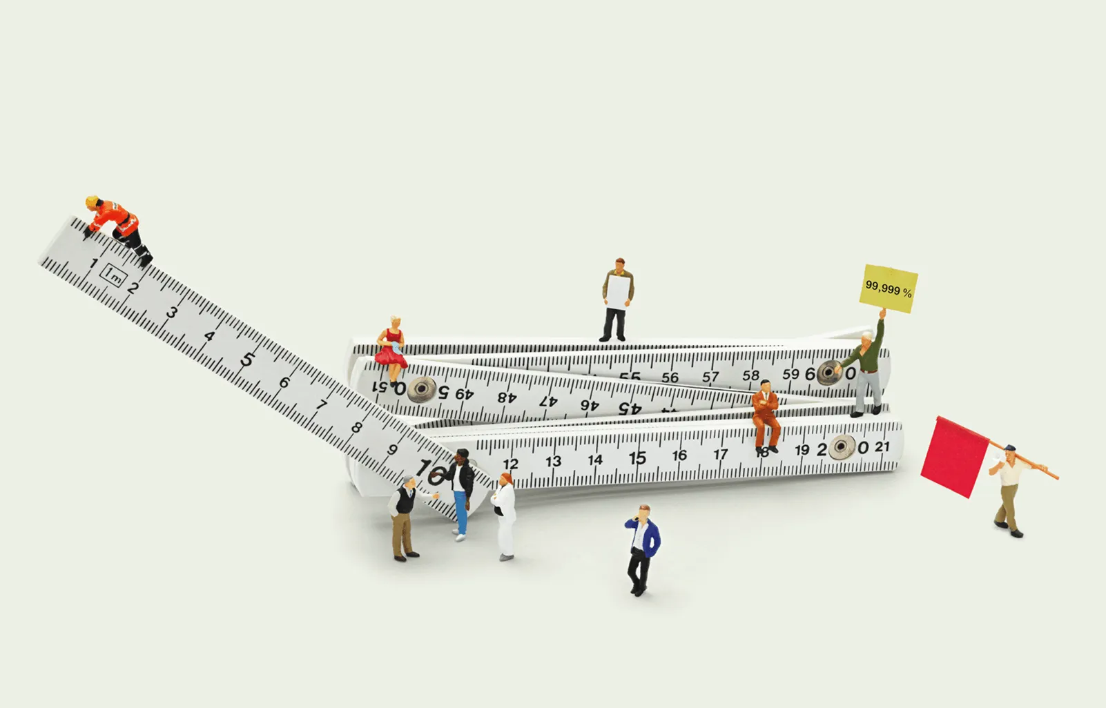 Miniature people working with measuring rulers, representing IT reliability, service levels and alignment with business outcomes.